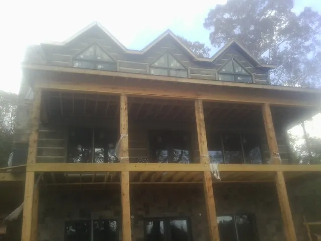 Dormers and porch framing on a large log home under construction — Roof Coating work by our crew in Leetonia