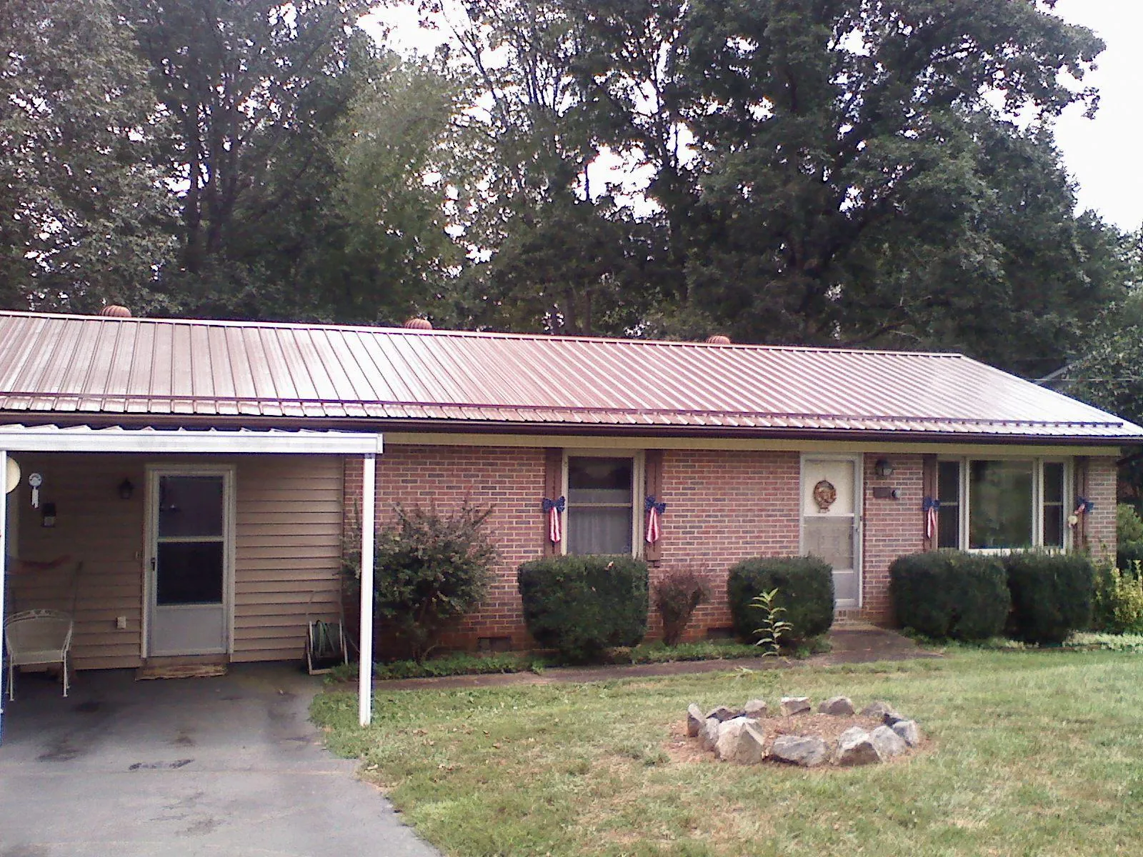 Bronze metal roof and carport on a brick ranch home — Roof Repair work by our crew in Leetonia