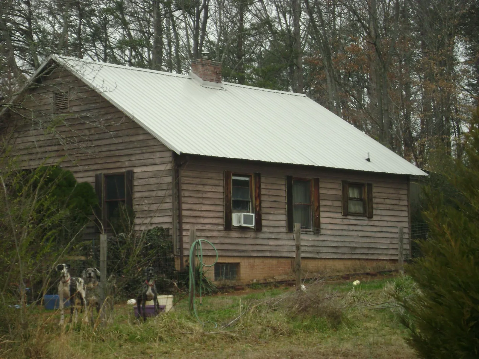White metal roof on an old wood sided farmhouse, from a Metal Roof Installation job in Leetonia